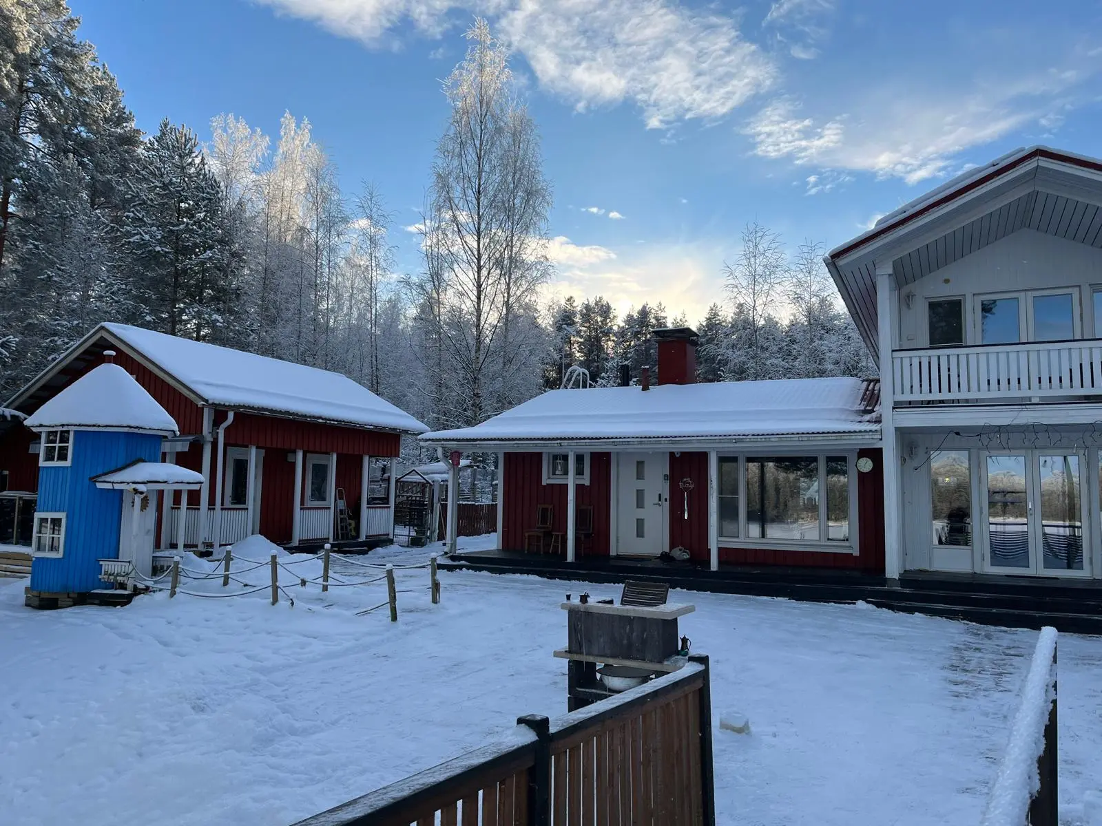 Talo ja aitta talvisessa pihapiirissä