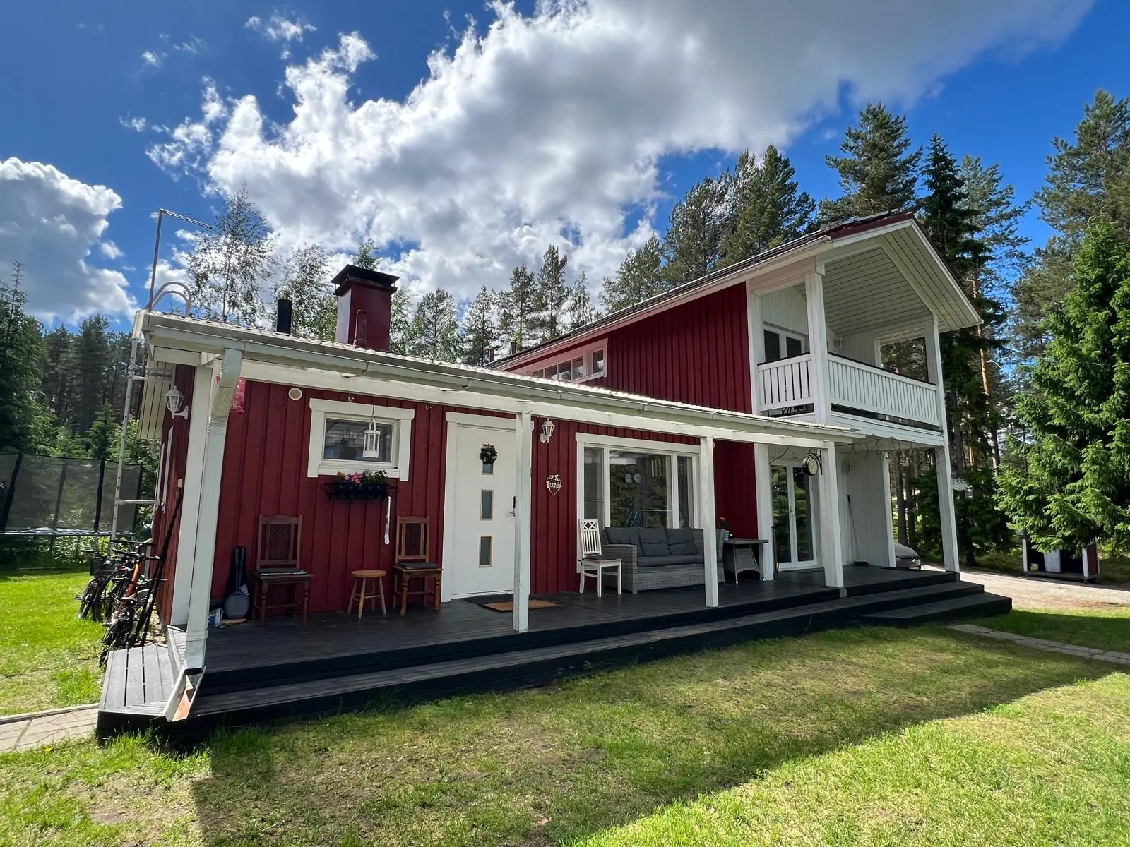 Villa Purnukan terassi ja kesäinen piha leveänä näkymänä