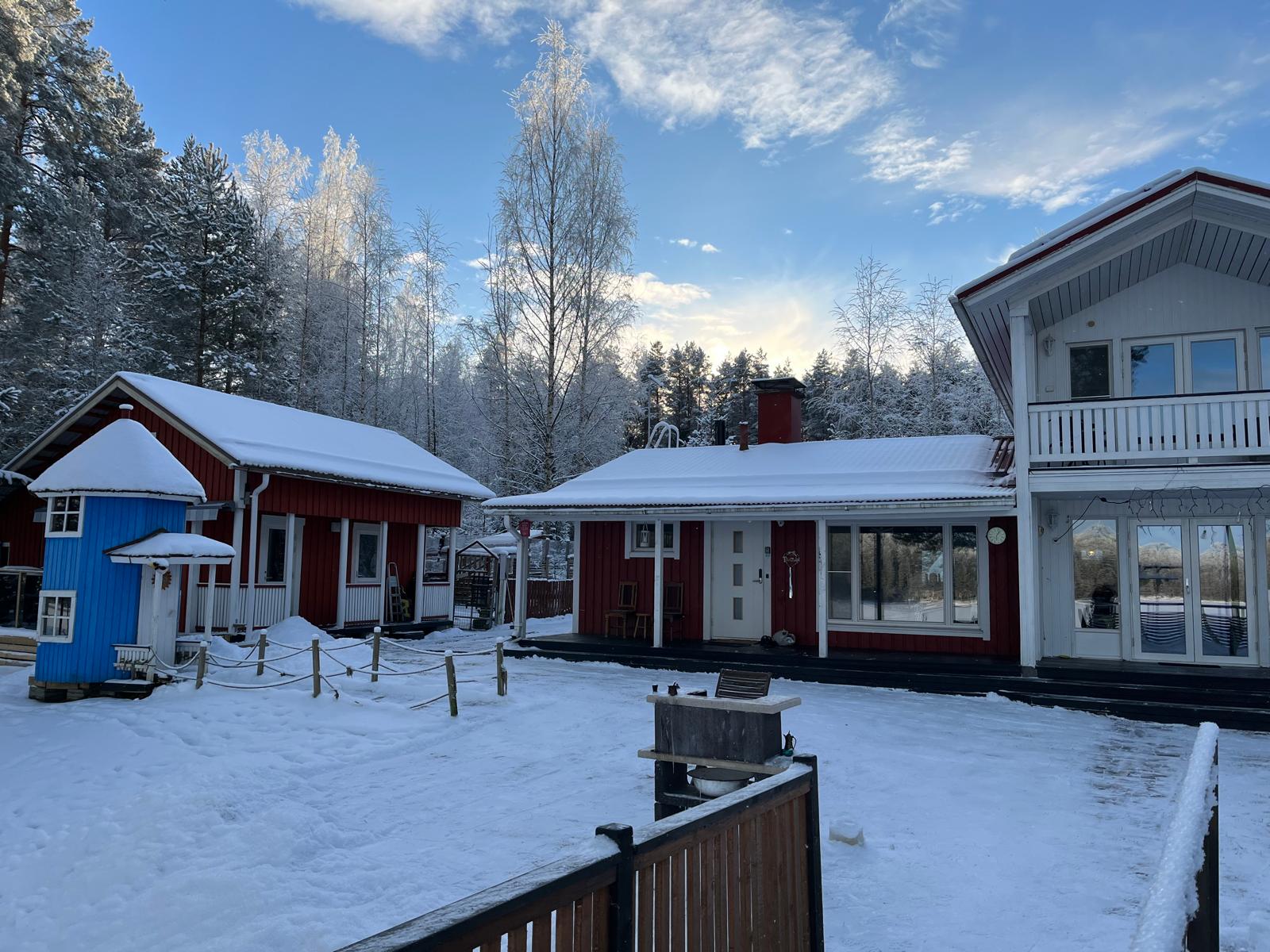 Talo ja aitta talvisessa pihapiirissä