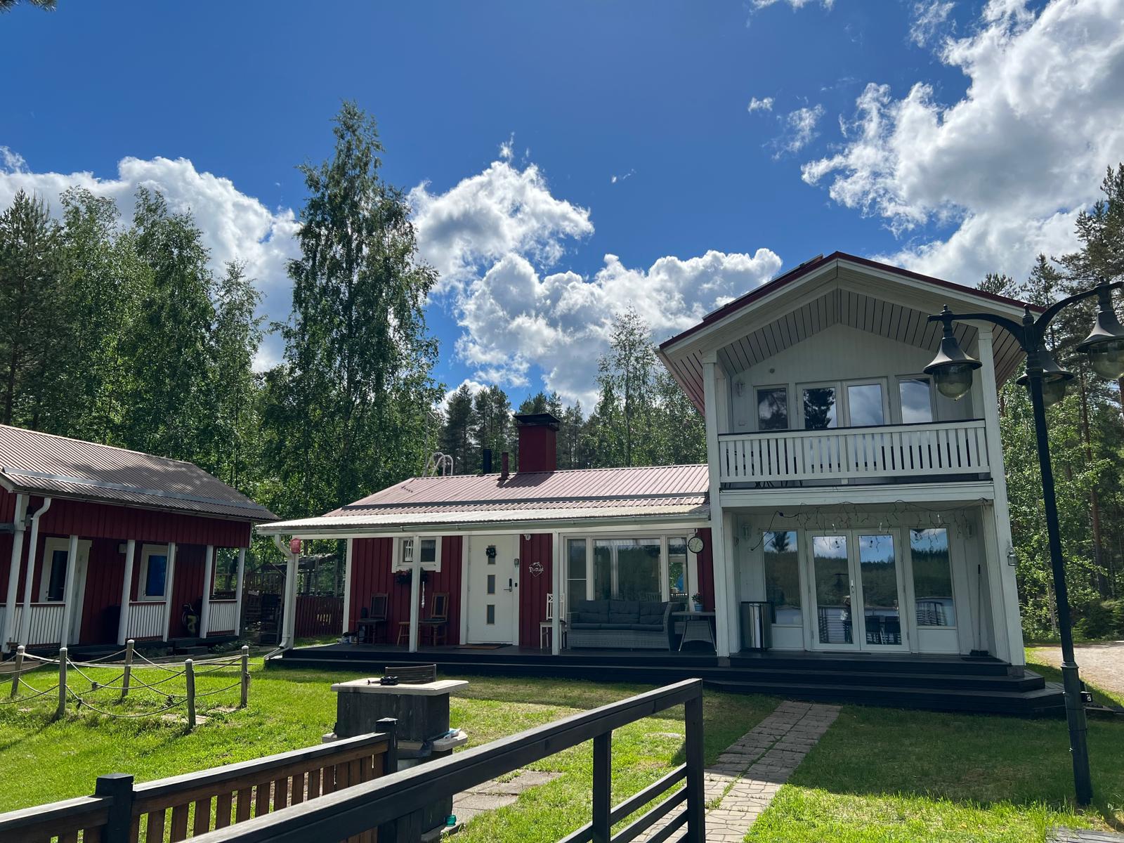 Villa Purnukan huvilan julkisivu kesäpihalta kumpupilvien alla, Kallaveden rannalla Vehmersalmella